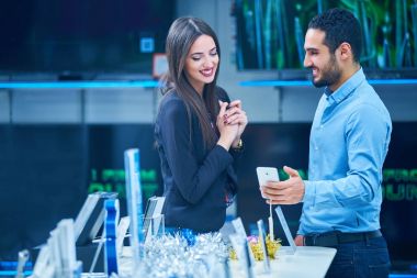 tüketici elektroniği genç bir çift satın almak en son dizüstü bilgisayar, televizyon ve fotoğraf kamera seyir saklamak