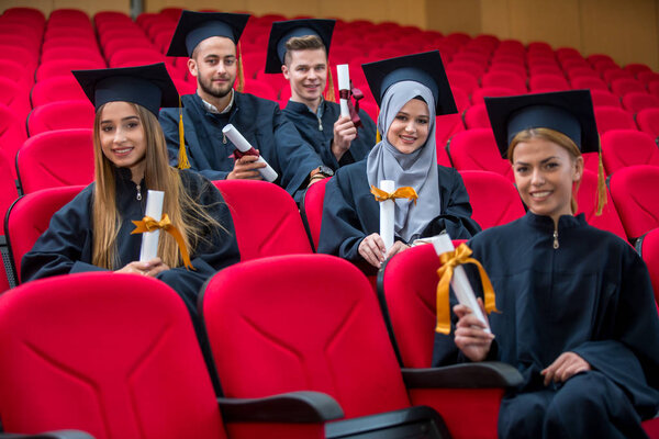 Group of Diverse International Graduating Students Celebrating, sitting and standing, concept