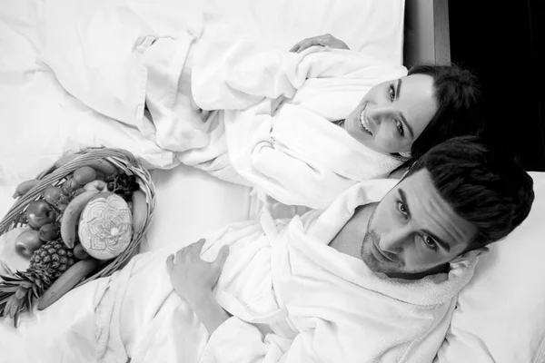 フルーツ バスケット 喜びとベッドでリラックスしたカップル — ストック写真
