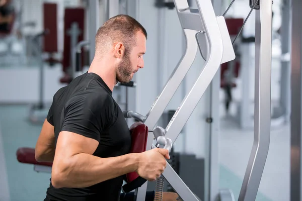 Determinado Jovem Homem Muscular Trabalhando Máquina Fitness Ginásio — Fotografia de Stock