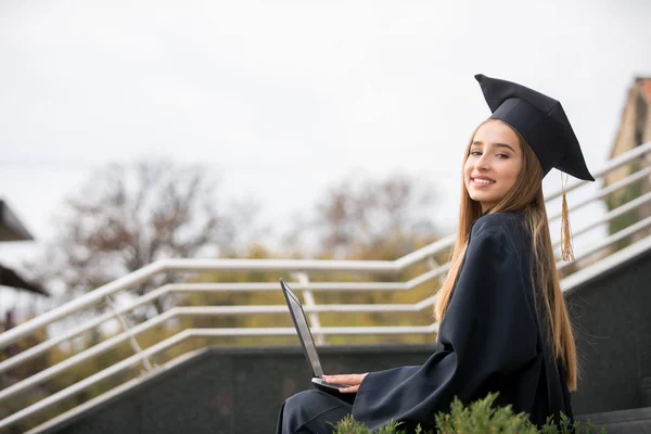 Pretty young  graduate girl with laptop