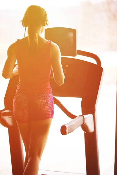 Girl runs on treadmill. Active girl in gym runs on treadmill. Athlete cardio activity on treadmill.