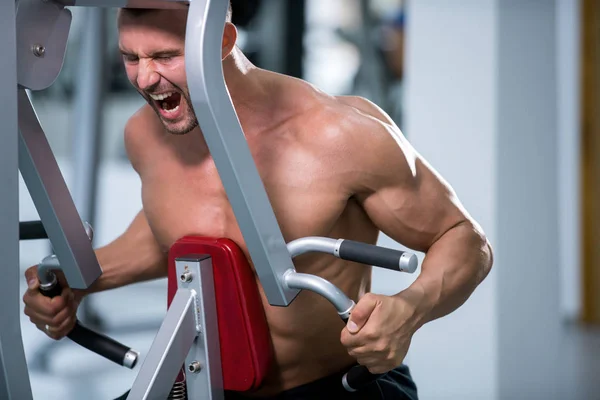 Determinado Jovem Homem Muscular Trabalhando Máquina Fitness Ginásio — Fotografia de Stock