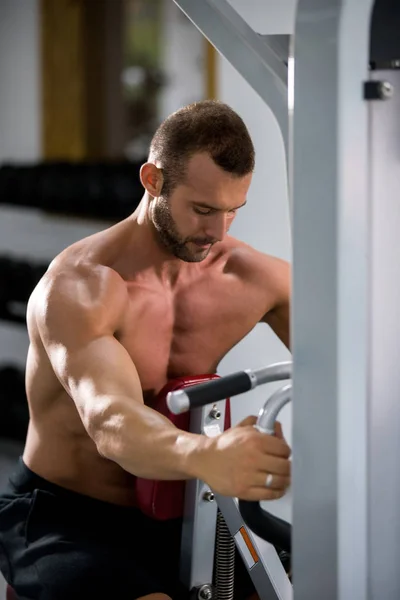 Determinado Jovem Homem Muscular Trabalhando Máquina Fitness Ginásio — Fotografia de Stock