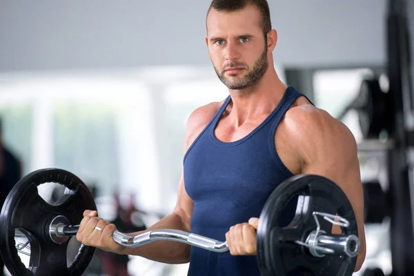sport, bodybuilding, lifestyle and people concept - young man with barbell flexing muscles and making shoulder press lunge in gym