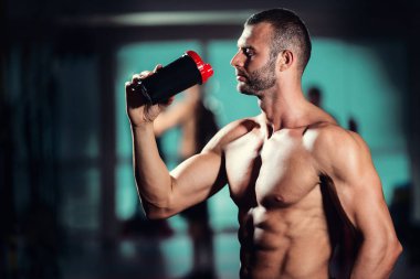 kas yakışıklı genç bir protein spor salonunda içiyor.