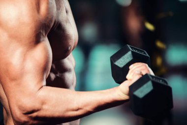 Yakışıklı ve güçlü bir adam güzel vücut salonunda egzersizleri yapıyor ile