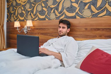 Dizüstü bilgisayarda kopyalama alanı boş ekranı ile rahat oda içinde beyaz çarşaf. Genç işadamı.