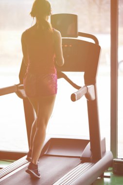 Kız koşu bandı üzerinde çalışır. Etkin kız spor salonunda koşu bandı üzerinde çalışır. Atlet kardiyo aktivite koşu bandı.