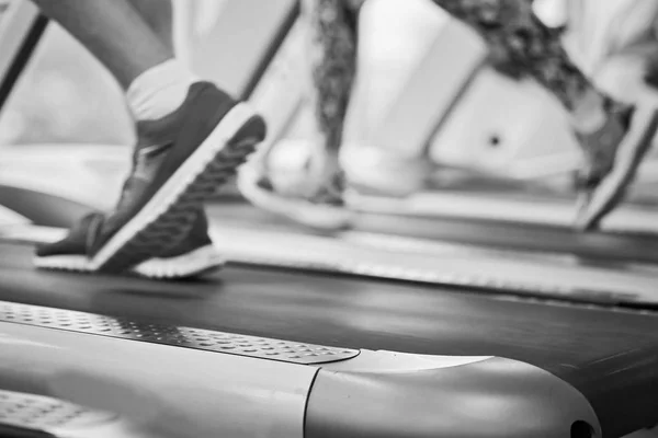Girl runs on treadmill. Active girl in gym runs on treadmill. Athlete cardio activity on treadmill.