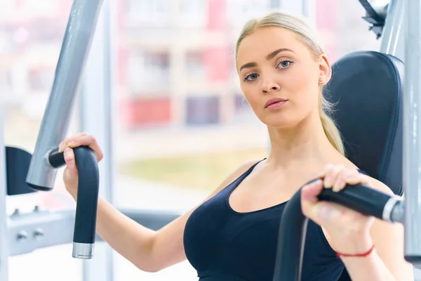 Beautiful fit woman works out in a fitness gym