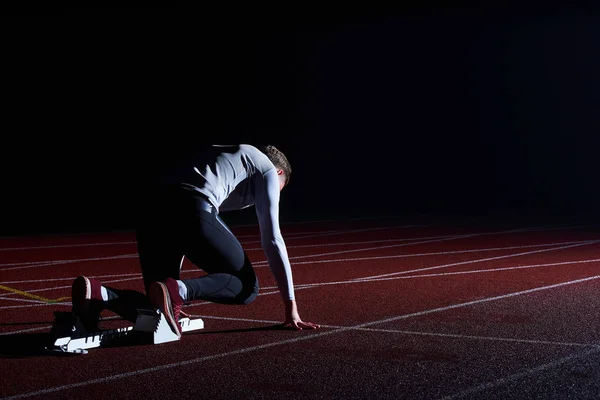 Sport. Sprinter leaving starting blocks on the running track.