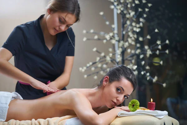 Spa woman. Female enjoying relaxing back massage in cosmetology spa centre. Body care, skin care, wellness, wellbeing, beauty treatment concept.