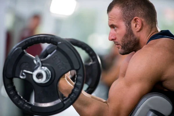 sport, bodybuilding, lifestyle and people concept - young man with barbell flexing muscles and making shoulder press lunge in gym