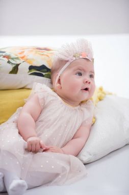 Odasındaki yatakta emekleyen bir bebeğin portresi.