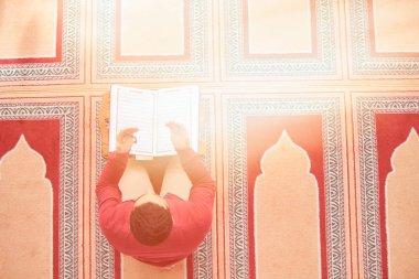 Dindar Müslüman adam caminin içinde dua ediyor.