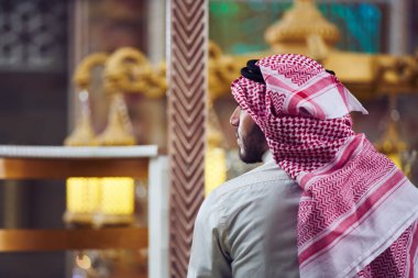 Dindar Müslüman adam caminin içinde dua ediyor.