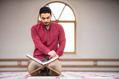 Dindar Müslüman adam caminin içinde dua ediyor.