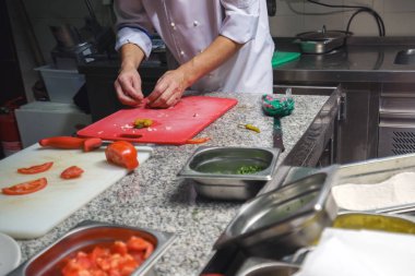 Restoranda aşçı sebze tabağı süslüyor, ellerinde mahsul, filtrelenmiş görüntü