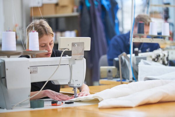 Швея новая приписана к машине на текстильной фабрике, бригадир кое-что объясняет
