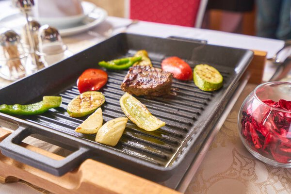 Beef Steak. Sirloin steak. Delicious juicy beef steak on fork. Grill vegetables.