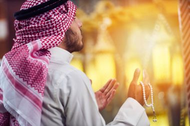 Dindar Müslüman adam caminin içinde dua ediyor.