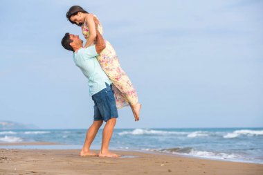 Kumsalda yürüyen çift.