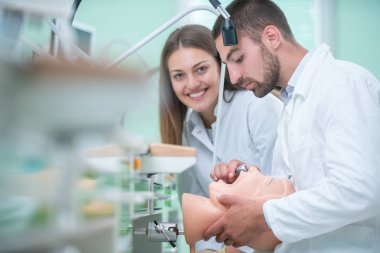 Takma diş, ağız hijyeni. Takma diş, takma diş, bir çalışma ve diş araçları içeren bir tablo üzerinde çalışırken protez eller.