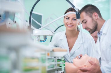 Takma diş, ağız hijyeni. Takma diş, takma diş, bir çalışma ve diş araçları içeren bir tablo üzerinde çalışırken protez eller.