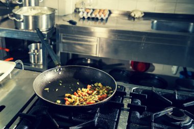 Restoranda aşçı sebze tabağı süslüyor, ellerinde mahsul, filtrelenmiş görüntü