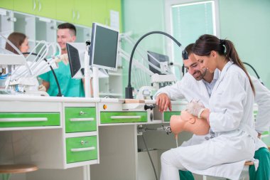 Takma diş, ağız hijyeni. Takma diş, takma diş, bir çalışma ve diş araçları içeren bir tablo üzerinde çalışırken protez eller.