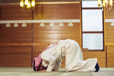 Dindar Müslüman adam caminin içinde dua ediyor.