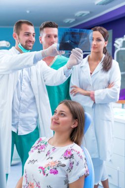 Diş hekimi diş bir hastanın röntgeni modern ofisinde gösterir.