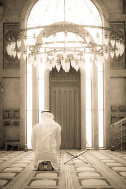 Dindar Müslüman adam caminin içinde dua ediyor.