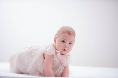 Odasındaki yatakta emekleyen bir bebeğin portresi.