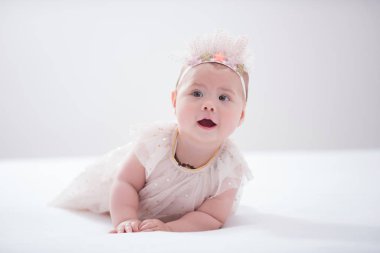 Odasındaki yatakta emekleyen bir bebeğin portresi.