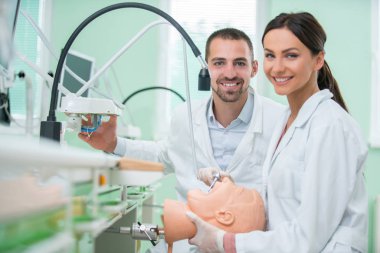 Takma diş, ağız hijyeni. Takma diş, takma diş, bir çalışma ve diş araçları içeren bir tablo üzerinde çalışırken protez eller.