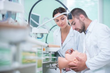 Takma diş, ağız hijyeni. Takma diş, takma diş, bir çalışma ve diş araçları içeren bir tablo üzerinde çalışırken protez eller.