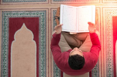 Dindar Müslüman adam caminin içinde dua ediyor.