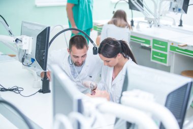 Takma diş, ağız hijyeni. Takma diş, takma diş, bir çalışma ve diş araçları içeren bir tablo üzerinde çalışırken protez eller.