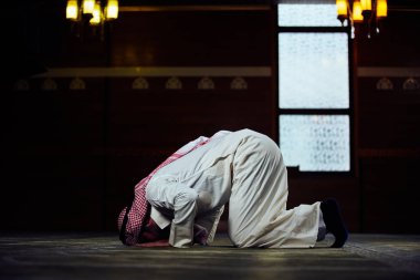 Dindar Müslüman adam caminin içinde dua ediyor.