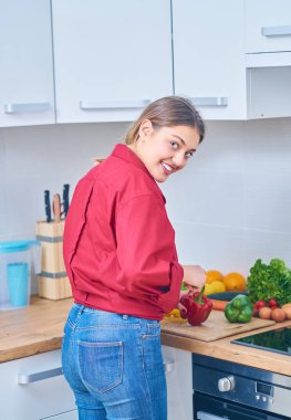 Portre sağlıklı meyve suyu evde kendini göstermek için bazı meyve ve sebze kesme genç bir kadın