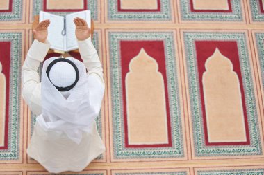 Dindar Müslüman adam caminin içinde dua ediyor.