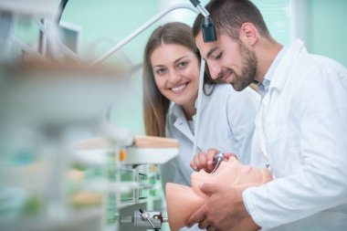 Takma diş, ağız hijyeni. Takma diş, takma diş, bir çalışma ve diş araçları içeren bir tablo üzerinde çalışırken protez eller.