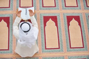 Dindar Müslüman adam caminin içinde dua ediyor.