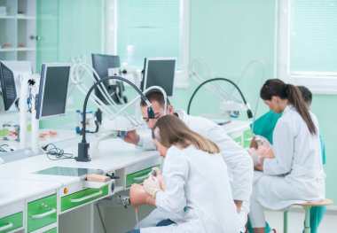 Takma diş, ağız hijyeni. Takma diş, takma diş, bir çalışma ve diş araçları içeren bir tablo üzerinde çalışırken protez eller.