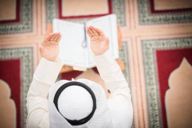 Dindar Müslüman adam caminin içinde dua ediyor.