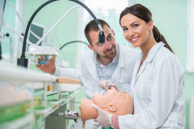 Takma diş, ağız hijyeni. Takma diş, takma diş, bir çalışma ve diş araçları içeren bir tablo üzerinde çalışırken protez eller.