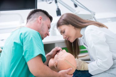 Takma diş, ağız hijyeni. Takma diş, takma diş, bir çalışma ve diş araçları içeren bir tablo üzerinde çalışırken protez eller.