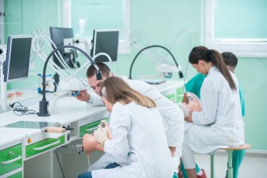 Takma diş, ağız hijyeni. Takma diş, takma diş, bir çalışma ve diş araçları içeren bir tablo üzerinde çalışırken protez eller.